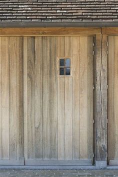 two wooden garage doors with one open and the other closed