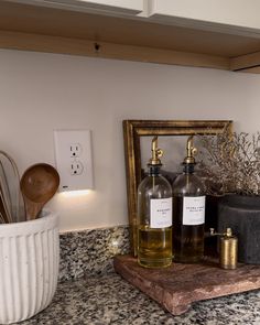 two bottles of wine sitting on top of a counter next to a potted plant