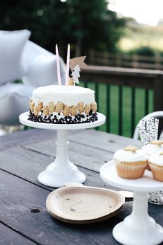 a table topped with two cakes and cupcakes