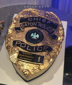 a cake shaped like a police badge on top of a white countertop with blue lights