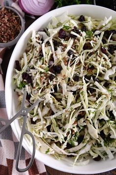 a white bowl filled with coleslaw and raisins