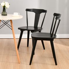 two black chairs sitting next to each other on top of a wooden floor