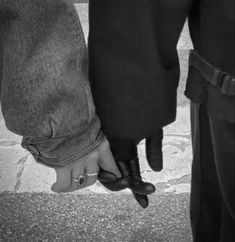 two people standing next to each other holding hands