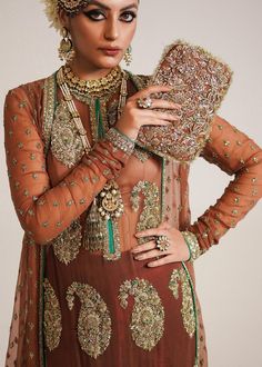 Pakistani Wedding Dress in Brown Sharara and Gown Style is a stunning attire embellished with Naqshi, Dabka, Sequins, Motifs, and Cut-dana. Fast shipping. Elegant Lehenga With Sheer Dupatta, Hand Embellished Anarkali Wedding Dress, Anarkali Hand Embellished Wedding Dress, Anarkali Hand Embellished Wedding Dress For Ceremony, Elegant Hand Embellished Organza Gown, Elegant Hand-embellished Organza Gown, Traditional Hand Embellished Formal Lehenga, Traditional Hand Embellished Lehenga For Formal Occasions, Formal Hand Embellished Lehenga