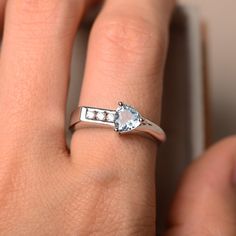 a woman's hand with a diamond ring on top of her finger and an engagement band