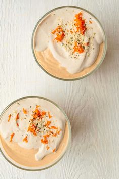 two bowls filled with food on top of a white table