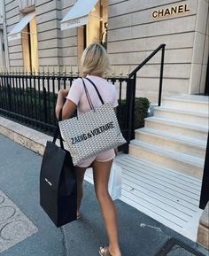 a woman walking down the street carrying shopping bags