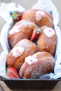 some sugar covered doughnuts and strawberries in a basket