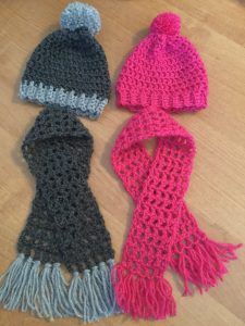 three knitted hats and scarfs laying on the floor