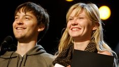 a man and woman standing next to each other at a podium with microphones in front of them