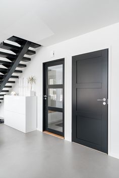 a black and white staircase leading up to the second floor in a modern style home