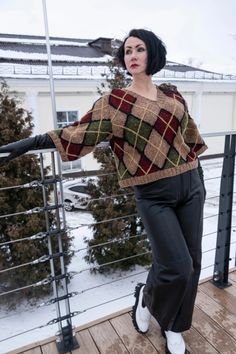 a woman standing on top of a wooden deck next to a fence and snow covered ground