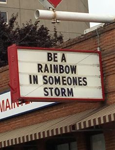 a sign that says be a rainbow in someone's storm