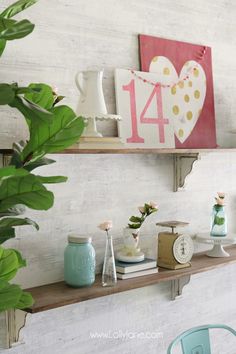 two shelves with vases and other items on top of them, one shelf has a clock