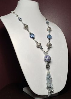 This Necklace is designed in beautiful blue and silver beads and accented with metal beads and crystals. It is designed to be a modern longer length with an elegant Tassel on the end.  This is a one of a kind stunning piece! Elegant Blue Dangle Crystal Necklaces, Elegant Blue Crystal Necklace, Blue Beaded Dangle Crystal Necklaces, Blue Beaded Dangle Crystal Necklace, Elegant Dangle Beaded Necklaces With Silver Beads, Elegant Blue Beaded Necklaces With Large Beads, Elegant Blue Beaded Necklace With Faceted Beads, Elegant Silver Beads Dangle Necklace, Elegant Blue Beaded Necklace With Large Beads