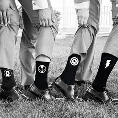 four people standing in the grass with their feet up wearing socks that have lightning symbols on them