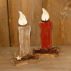 two red candles sitting on top of a wooden table