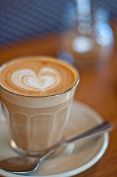 a cappuccino on a saucer with a spoon