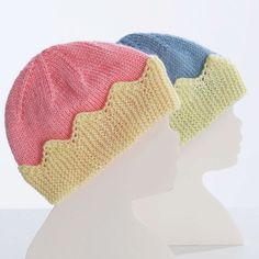 two knitted hats on top of a white mannequin's head in front of a white background