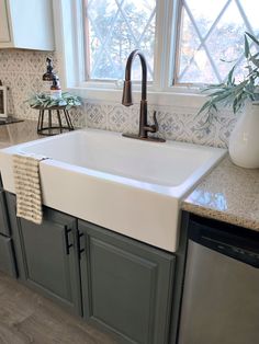 a white kitchen sink sitting under a window