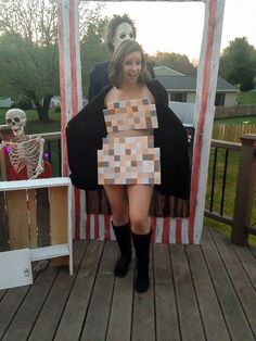 a woman in a costume standing on a deck with a skeleton behind her and a mirror