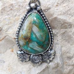 An unusual Chrysocolla teardrop-shaped stone features crystal-like matrics within the stone. The teardrop shape stone is framed with a beaded wire. At the bottom of the pendant, there are handmade Moroccan-style flower and leaf motifs giving this pendant a Moroccan flare. The cool blues and greens of this stone will pair nicely with most of your wardrobe. Vintage Teardrop Natural Stones Jewelry, Bohemian Teardrop Agate Jewelry, Bohemian Sterling Silver Pendant Drop Necklace, Handmade Teardrop Jewelry For Healing, Bohemian Agate Teardrop Pendant Necklace, Handmade Agate Teardrop Necklace, Handmade Agate Teardrop Necklaces, Handmade Teardrop Agate Necklaces, Turquoise Drop Bohemian Jewelry