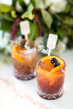 two glasses filled with drinks sitting on top of a table