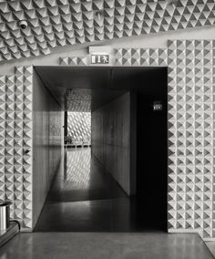 an empty hallway with geometric tiles on the walls