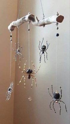 three spider mobiles hanging from a tree branch