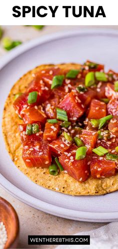 a small pizza on a white plate with green onions and tomato sauce in the middle