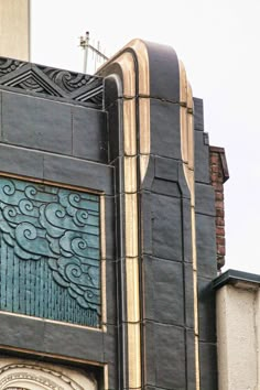 a clock on the side of a building with an ornate design and weathervane