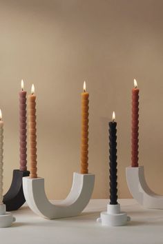 five candles are lined up in different shapes and sizes