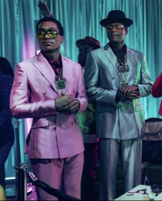 three men in pink suits and sunglasses standing next to each other