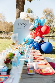 a long table with balloons and plates on it