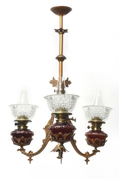 an antique chandelier with three glass shades