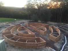 a circular wooden structure sitting on top of a dirt field