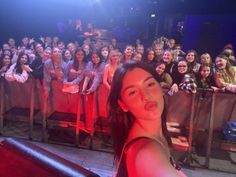 a woman standing in front of a large group of people at a concert or show