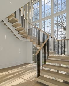 a staircase in an empty room with large windows