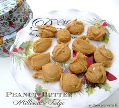 peanut butter cookies are on a plate next to a christmas cookie tin with holly designs