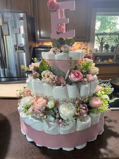 a tiered cake decorated with flowers and the number one on it's side