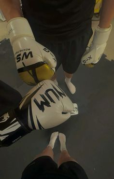 two pairs of boxing gloves sitting on top of each other in the middle of a gym