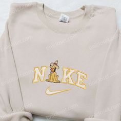 The Nike x Pluto Farmer Embroidered Shirt is a must-have for Disney fans! Made from premium cotton, this shirt features a unique collaboration between Nike and Pluto, showcasing an adorable embroidered design of Pluto as a farmer. With its soft fabric and relaxed fit, this shirt ensures maximum comfort all day long. Whether you’re a [...] Nike Cartoon, Nike Inspired, Embroidered Apparel, Best Family Gifts, Mike Wazowski, Shirt Nike, Daisy Duck, Hoodie Material, Custom Nikes