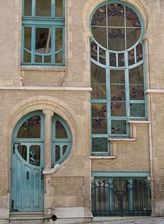 an old building with arched windows and blue doors