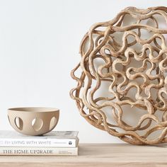 a white bowl sitting on top of a wooden table next to two bookends