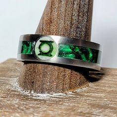 the green lantern ring is sitting on top of a piece of wood