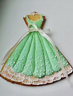 a cookie shaped like a green dress with white polka dots