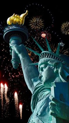 fireworks light up the sky above the statue of liberty