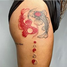 a woman's thigh with fish and yin - yang tattoos on her thighs,