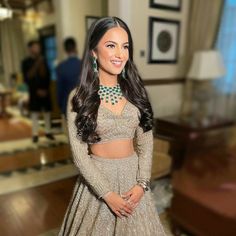 a beautiful woman in a long dress posing for the camera with her hands on her hips