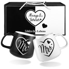 two black and white coffee mugs in front of a box